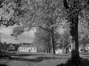Árvores em folha e vista dos edifícios da aldeia de Joseph Hardman