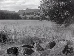 Vista de Loughrigg Tarn, em primeiro plano estão algumas pedras colocadas no chão de Joseph Hardman
