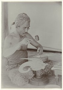 Homem javanês usa martelo e instrumentos para criar uma imagem semelhante a uma figura humana