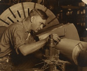 Homem com micrómetro a medir um veio ao milésimo de polegada. de Lewis W. Hine