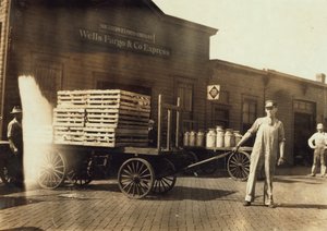 Homens na frente de um depósito de Wells Fargo e Co Express com caixas e latas de leite, Springfield, Missouri, 1916 de Lewis Wickes Hine