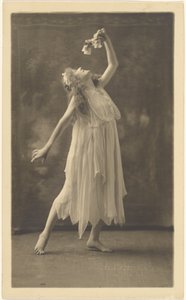 [Bailarina com uma flor diante de uma tapeçaria]