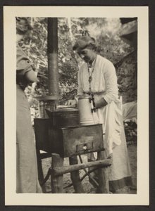 [Mulher a utilizar o fogão de exterior]. de Louis Fleckenstein