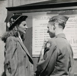 Soldado com uma mulher jovem em frente ao cartaz de um teatro vienense de Luigi Leoni