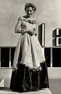 Modelo em vestido de baile criado pela casa de alta costura "Graldi". O artigo é caracterizado por uma linha de pescoço baixa e saia cheia decorada com apliques florais. (foto a p/b) de Luis Bogino