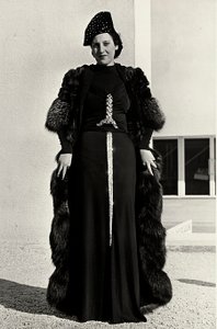 Modelo em vestido de noite criado pela casa de alta costura italiana "Dragoni". A fonte do artigo tem uma decoração de lantejoulas brilhantes em forma de espada. Um chapéu e um sobretudo de pele completam o conjunto. (foto a p/b)