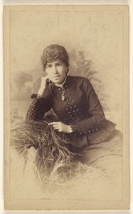 [Mulher não identificada sentada com a mão na bochecha, posada num monte de feno] de Miller and Company
