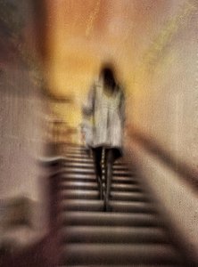 Mulher a subir umas escadas desfocadas