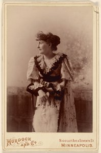 [Mulher não identificada de perfil, apoiada numa cadeira, segurando um leque de penas] de Murdock and Company