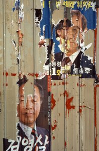 Cartazes de campanha destruídos relativos à eleição entre Roh Tae Woo, Kim Young Sam e K...