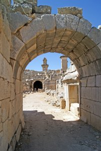 Vista através da entrada abobadada do teatro Xanthos no fosso da Orquestra, mostrando pilar e túmulo de Harpia, Xanthos, Turquia (foto) de Roman
