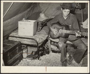 Apanhador de morangos migrante branco na cama numa tenda perto de Hammond, Louisiana de Russell Lee