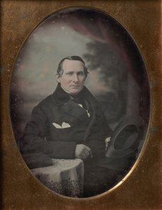 Homem vestindo casaco e luvas, segurando o chapéu, sentado na frente do pano de fundo pintado ao ar livre, década de 1840. de Samuel Broadbent Jr..
