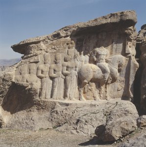 Relevo de rocha representando Shapur I (241-72 dC) e sua família usando emblemas heráldicos em seus chapéus, com uma inscrição em três línguas no cavalo em grego, parta e persa médio. de Sasanian