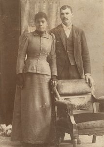 Fotografia de um casal afro-americano em pé atrás de uma cadeira, ca. 1890. de Schmitz Studio