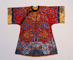 Um manto semiformal de cetim vermelho bordado em sedas e fios dourados com dragões em meio a nuvens ondulantes acima de uma borda de ondas turbulentas do mar (cetim, seda) de School Chinese