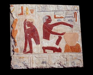 Arte Egípcia Antiga: cozer pão. Um homem faz pasta de bolo, outro monitora o cozimento dos moldes de pão. Pedra calcária (2500-2350 a.C.) 5ª dinastia. Paris, Musee Du Louvre