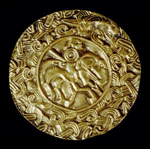 Arqueologia da Idade Média (Idade Média). Arte bárbara da Lombardia: disco de ouro. No centro está um santo a cavalo com uma lança e ao redor de motivos animais. Arte lombarda, em torno de 600. Dim: 47 cm Itália, Cividale del Friuli, Museu Arqueológico. de School Lombard