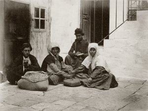 Mulheres moendo farinha com moinhos redondos dentro de um pátio de uma casa em Jerusalém, 1867