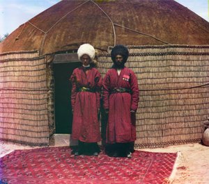 Dois homens de pé em um tapete, em frente ao Yurt