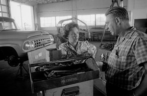 A condutora de camiões Mildred Cooper conversa com um mecânico numa garagem de Ted Spiegel