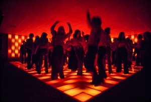 Jovens bailarinos numa discoteca a dançar numa pista iluminada de Ted Spiegel