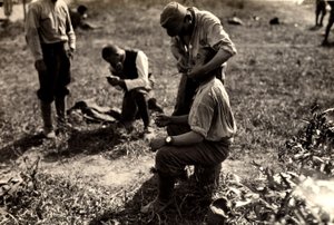 Prisioneiros austríacos durante a Primeira Guerra Mundial em Bagnaria Arsa, Udine, Itália; em primeiro plano, um soldado rapa um companheiro de soldado, 02/04/1916 (foto a p/b)