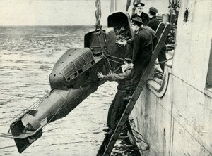 Levantar um torpedo equipado com carruagem a bordo de um navio, Segunda Guerra Mundial, 1945. de Unbekannt