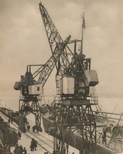Guindastes móveis enormes em Tilbury balançam a carga de uma embarcação segura, c1935. de Unbekannt