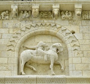 Arte românica: detalhe da fachada representando Hugues de Surgeres e Geoffroy de Vendome ou o Imperador Constantino I o Grande cujo pé do cavalo pisaria Heresie e Cristo triunfante do Mal e da Morte, Notre-Dame de Surgeres (17700) de Unbekannt