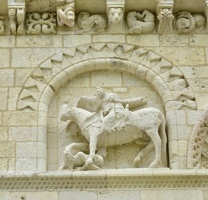 Arte românica: detalhe da fachada representando Hugues de Surgeres e Geoffroy de Vendome ou o Imperador Constantino I o Grande cujo pé do cavalo pisaria Heresie e Cristo triunfante do Mal e da Morte, Notre-Dame de Surgeres (17700) de Unbekannt