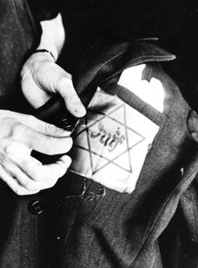 Costurando a estrela amarela identificando um judeu em uma jaqueta, Paris ocupada pela Alemanha, 1942 de Unbekannt
