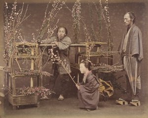 [Dois homens japoneses e uma mulher japonesa posando com galhos floridos], década de 1870., de Unbekannt