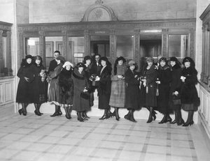 Estados Unidos: c.1926 Um grupo de mulheres de pé nos guichês de "Poupança" de um banco. (foto p/b) de Unbekannt