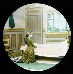 Uma menina ajoelhada em oração à cabeceira da cama, escorrega de lanterna mágica, c 1890 de Unbekannt