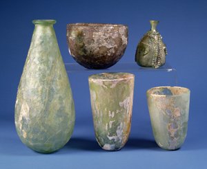 No sentido horário a partir da esquerda: frasco de vidro verde em forma de pêra, Sasanian, século 3-7 d.C.; taça de vidro âmbar pálido, Sasanian, século 5-6 d.C.; frasco de vidro verde islâmico em forma de pêra, século 8-12 d.C.; dois copos de vidro verde  de Unbekannt