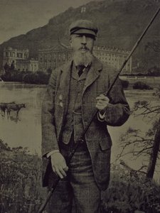 Retrato de estúdio do 8º Duque de Devonshire em tweeds segurando a cana de pesca em frente a uma tela impressa retratando Chatsworth de William M. Timlin