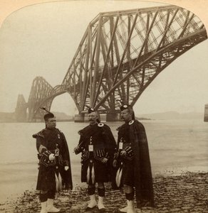 Homens de Highland se vestem em frente à Forth Bridge, na Escócia. de Underwood and Underwood
