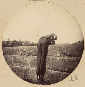 [Homem de chapéu debruçado sobre um muro de pedra]. de Unknown artist