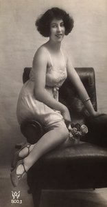Uma jovem mulher posando com o seu saiote, sentada numa poltrona de Unknown photographer