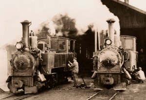 Duas locomotivas a vapor em manutenção por dois trabalhadores. de Unknown photographer