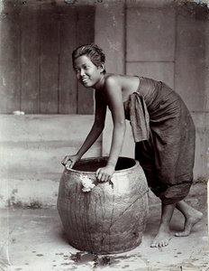 Jovem tailandesa sorridente, a empurrar um contentor grande de Unknown photographer