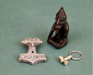 Amuletos das divindades Viking: em primeiro plano, dois pequenos martelos de prata simbolizando o deus Thor. A estatueta representa Freyr, deus da fertilidade. Museu Histórico de Estocolmo, Suécia.