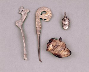 Várias peças de vestuário e jóias Viking, na parte superior direita, uma representação da divindade Odin. Estocolmo, Historiska Museet