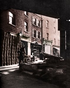 Cestas de frutas empilhadas contra casas no Borough Market, Londres, 1926-1927