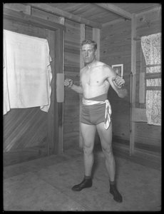 Pugilista inglês William Thomas Wells (Bombardeiro Billy Wells), posando em togs de treinamento com polias de peso, c.1911 de William Davis Hassler