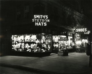 Frentes de loja iluminadas anunciando chapéus de Stetson de Smith, sapatos, licores, c.1910-21 de William Davis Hassler