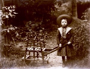 Menina com carrinho em um jardim, início do século XX (foto p/b) de . .