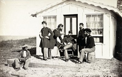 Cinco soldados da Guerra Civil se reuniram na varanda suja fora de casa, juventude afro-americana sentada perto deles, 1861-65 de American Photographer