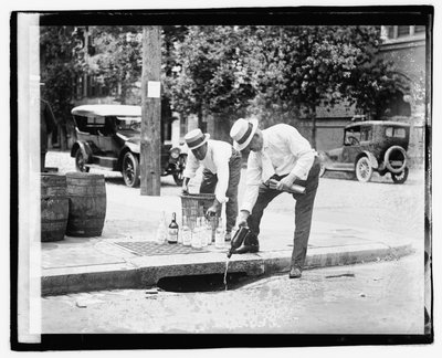 Dois homens despejando bebida no bueiro, 8 de julho de 1921 (foto em branco) de American Photographer